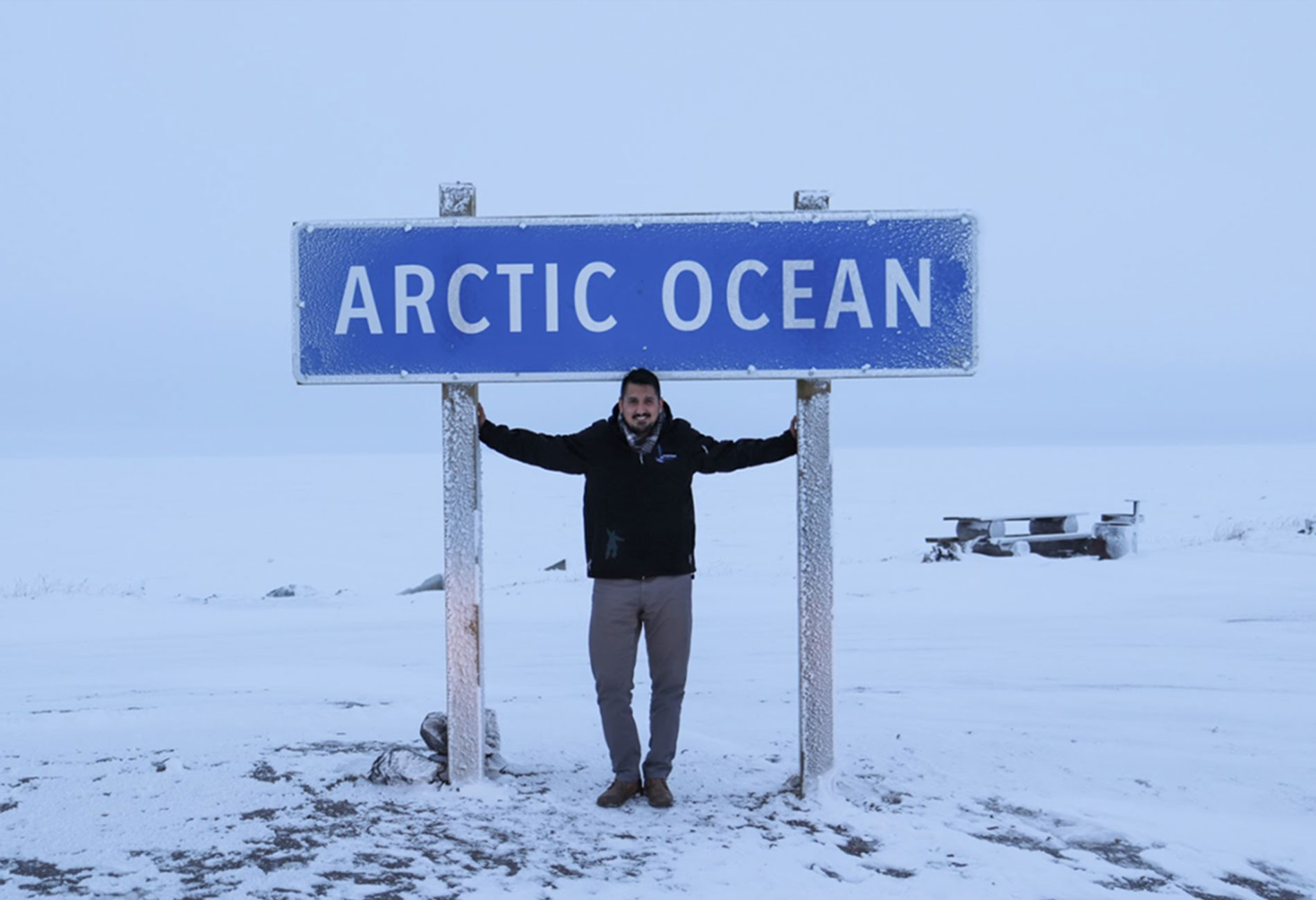 Kipnik's CEO and Founder stands under a sign for the Arctic Ocean in the middle of winter